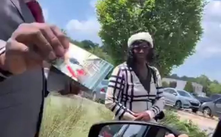 A Nigerian pastor speaks to a woman on a street in the United States during an evangelism outreach before she tells him pastors should teach business and financial education instead of religion.