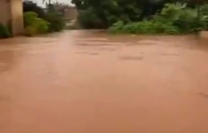 Floodwaters overwhelm Upper Sokponba Road in Benin City, Edo State, leaving roads submerged as residents struggle to move through the flooded area after heavy rainfall.