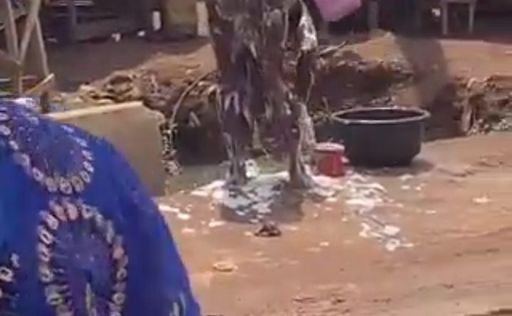 Trending video allegedly shows a young woman bathing naked in an open area inside a busy market beside a police station.